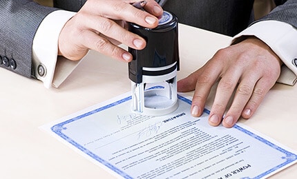 Homme utilisant un tampon encreur sur un document.